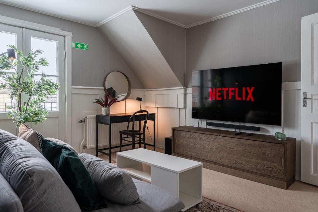 sala de estar con sofá y TV de pantalla plana en Guestly Homes - Central Charm, en Boden