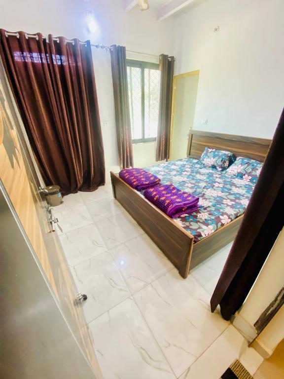 a bedroom with a bed and a window at Nirupam Sadan HomeStay in Vrindāvan