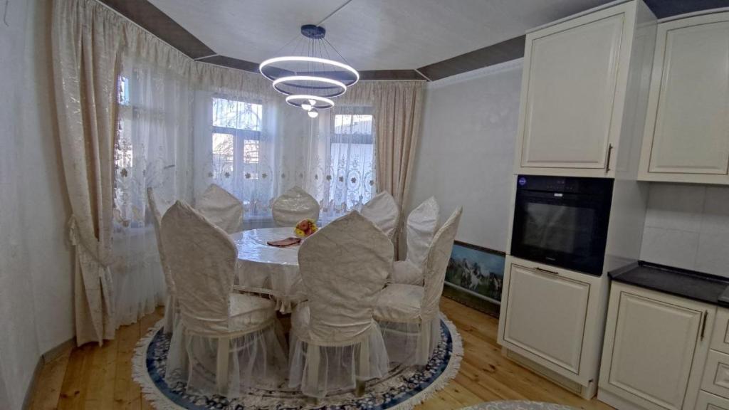 a kitchen with a table and chairs and a television at Emir guest house in Batken