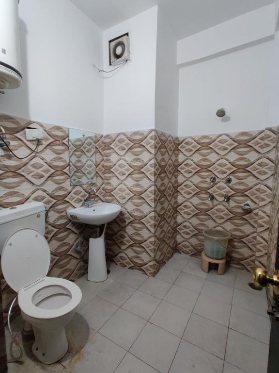 ein Bad mit einem WC und einem Waschbecken in der Unterkunft Hotel Parbhat Palace in Katra