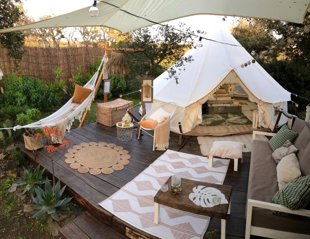 a tent with a couch and a table at Glamping - La Casa del Piano in Chiclana de la Frontera
