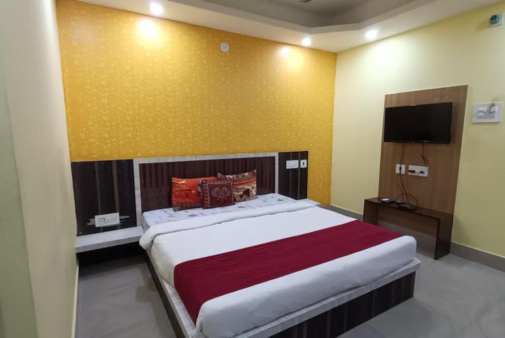 a bedroom with a large bed and a television at Goroomgo Sashi Near Golden Beach Puri - Excellent Service in Puri