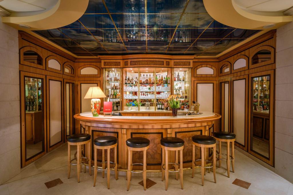 a bar in a restaurant with stools around it at Hotel Parc Belair in Luxembourg