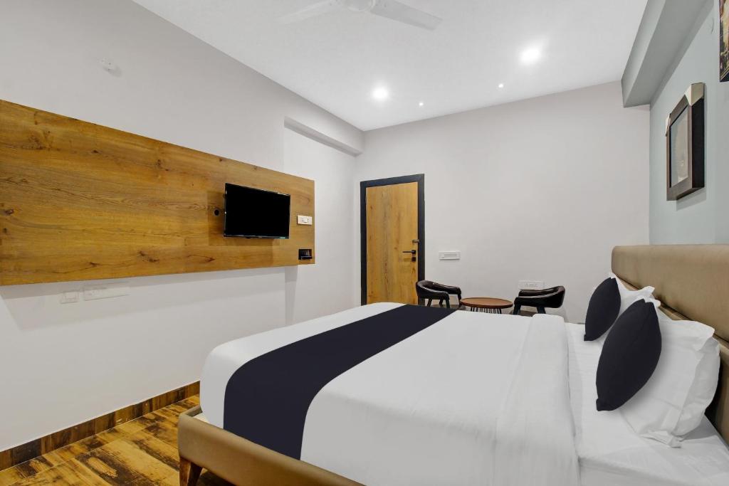 a bedroom with a bed and a tv on the wall at Townhouse Hitec City Near Image Hospital in Hyderabad
