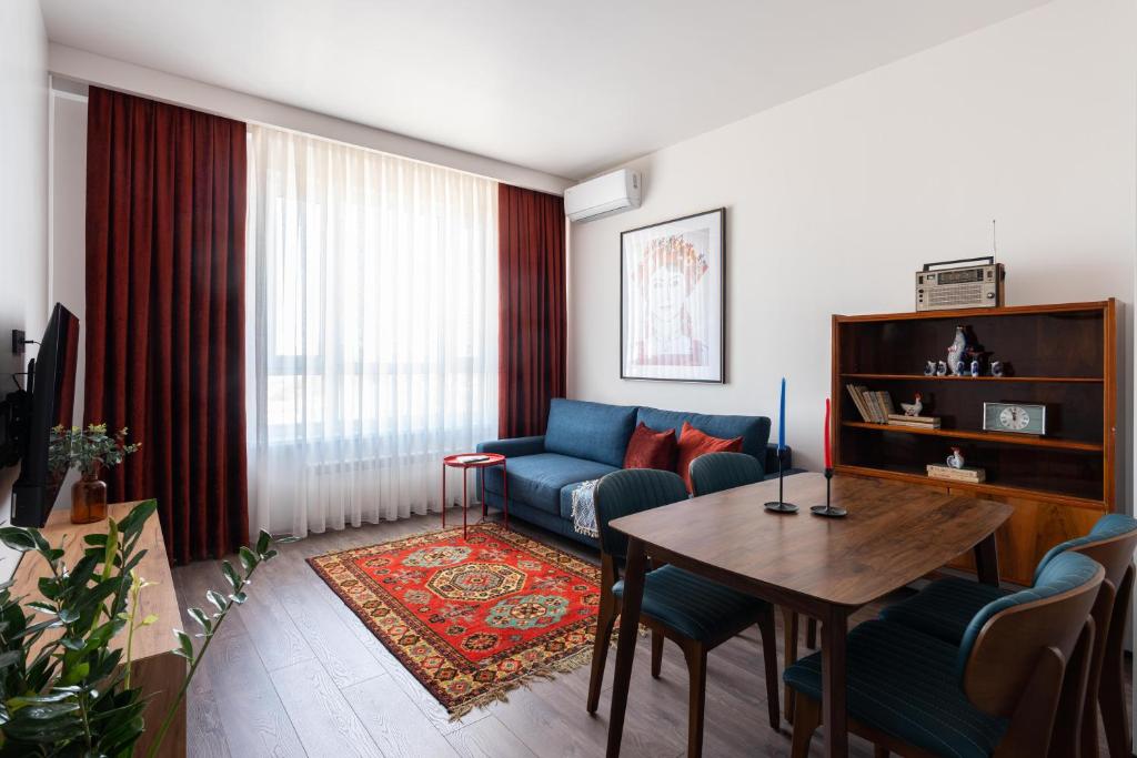 sala de estar con sofá azul y mesa en Stylish & Modern Apartment I Blueloft 48, en Tashkent