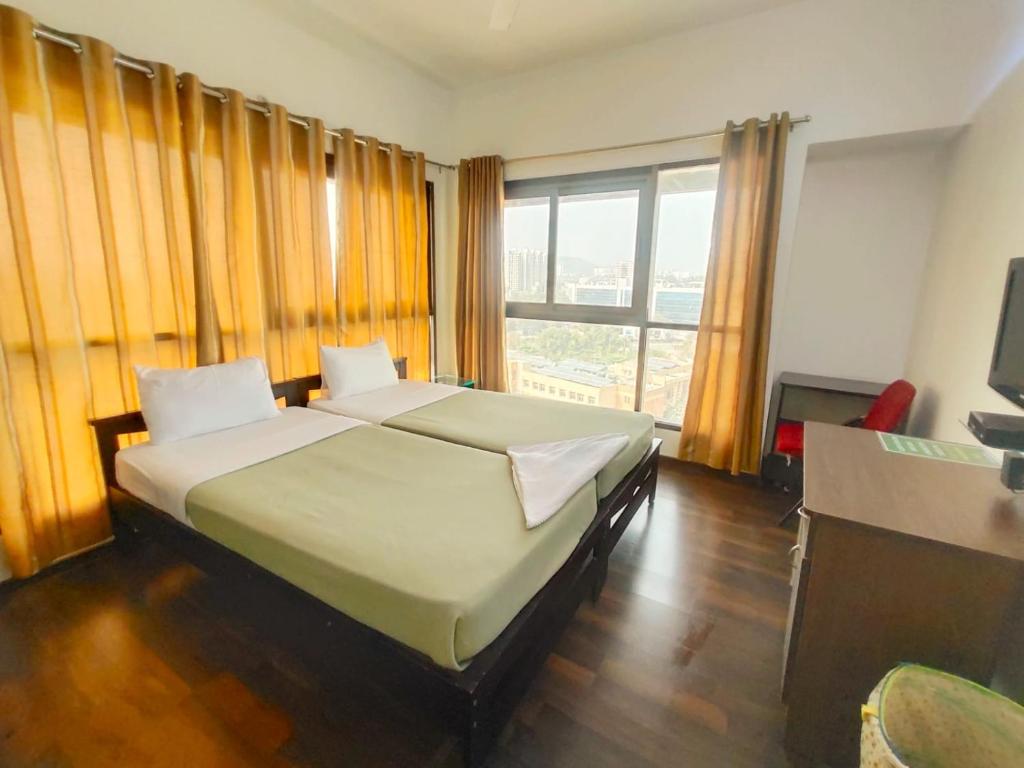 een slaapkamer met een bed en een groot raam bij Private room in Blueridge in Hinjewadi