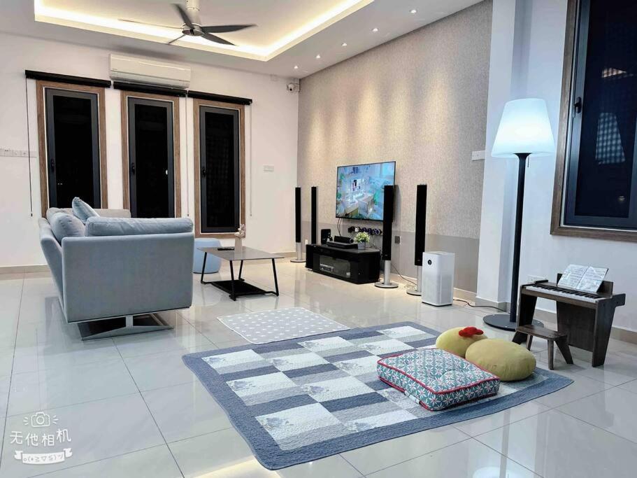 ein Wohnzimmer mit einem Sofa und einem TV in der Unterkunft Royal Palace Homestay in Taiping