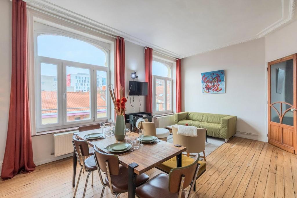 een woonkamer met een tafel en stoelen en een bank bij 2 bedroom apartment with terrace, near Lille in Lille