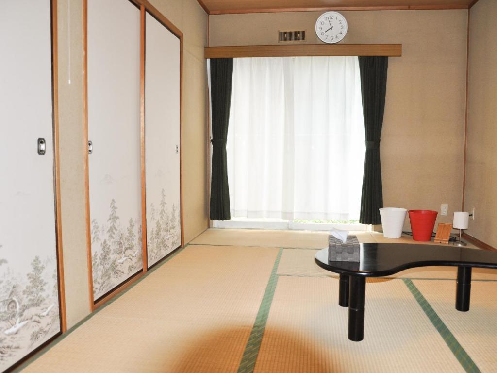 ein Wohnzimmer mit einem Tisch und einem Fenster in der Unterkunft Tuktuk House in Kawagoe