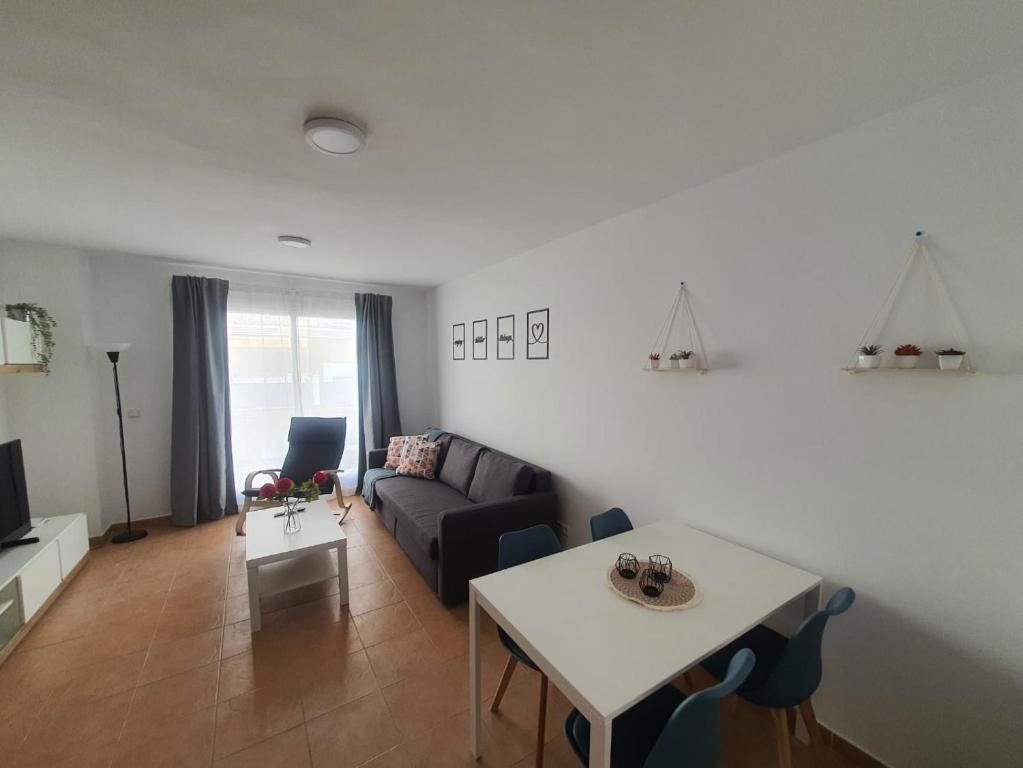 een woonkamer met een bank en een tafel bij Moderno Apartamento 3 dormitorios, garaje y piscina in La Algaba