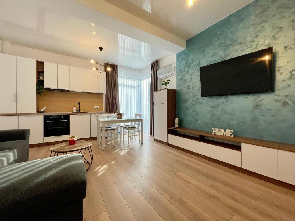 Il comprend une cuisine et un salon avec une télévision murale. dans l'établissement Seaside Apartments Mamaia Nord, à Mamaia Nord – Năvodari