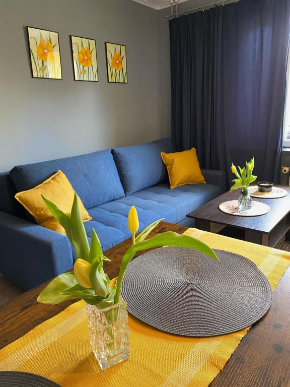 a living room with a blue couch and a table at Apartament Asspazja in Stronie Śląskie