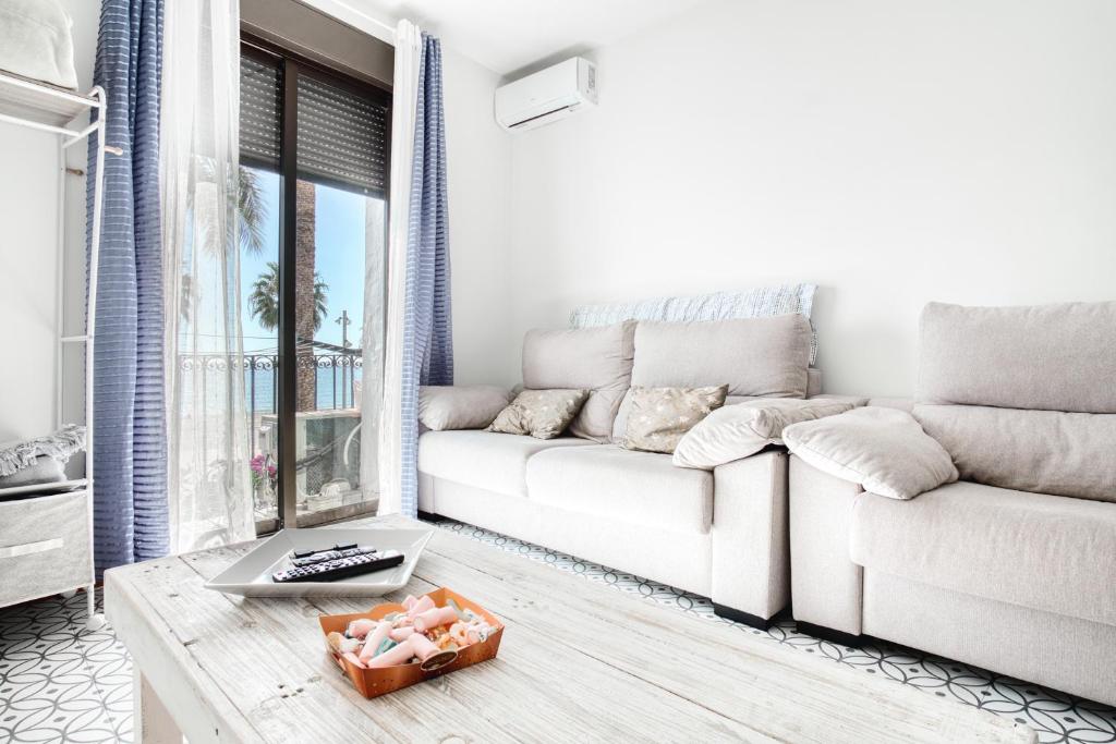 a white living room with a couch and a table at El Desembarco in Villajoyosa