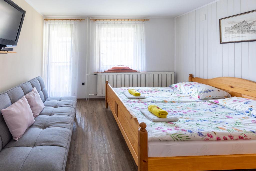 ein Schlafzimmer mit einem Bett und einem Sofa in der Unterkunft Apartma pri Andreju in Bohinj