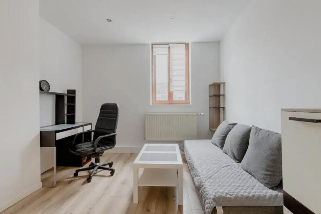 Beautiful fully renovated apartment في بروكسل: غرفة معيشة مع أريكة ومكتب