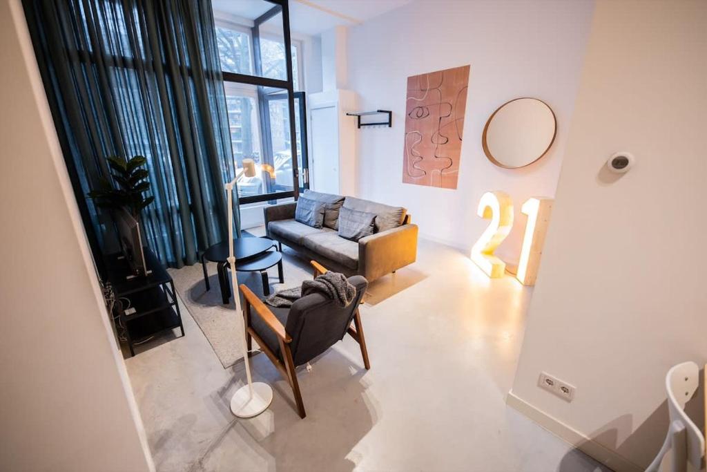 sala de estar con sofá y silla en Warm 2 Bedroom Serviced Apartment 59m2 -LK21- en Róterdam