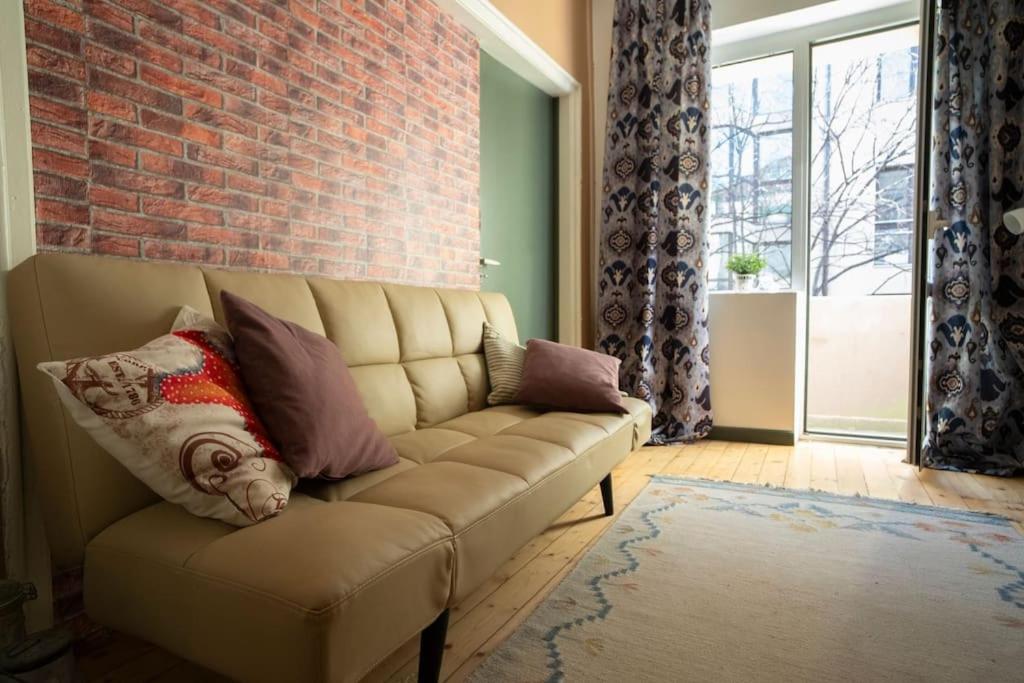 - un salon avec un canapé et un mur en briques dans l'établissement 2BDR Flat in Centre Sofia (NDK), à Sofia