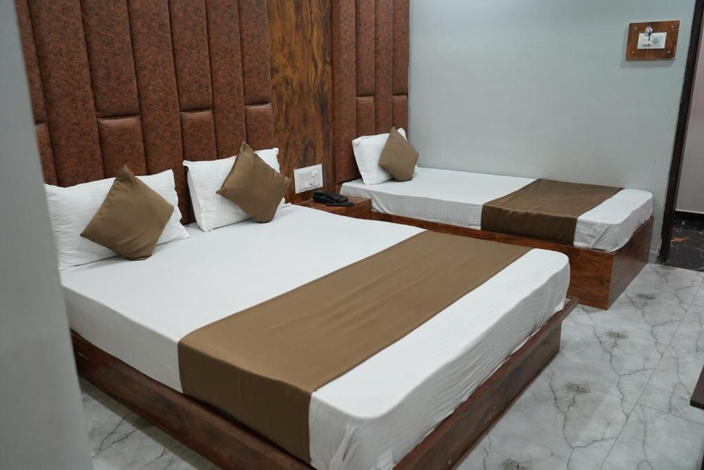 a couple of beds in a room at HOTEL PR VILLA in Gandhinagar