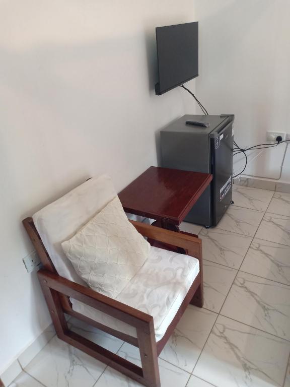 Elle dispose d'une télévision, d'une chaise et d'un bureau avec une télévision. dans l'établissement Anna Mtwapa Luxury Apartments, à Mtwapa