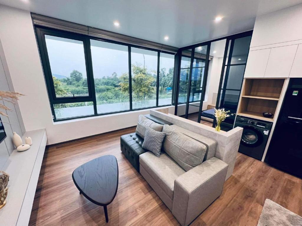 a living room with a couch and some windows at GEM II APARTMENTS in Xóm Niêm