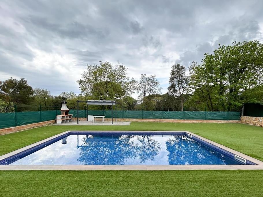a swimming pool in the middle of a grass field at Espectacular casa con piscina en Tordera in Tordera