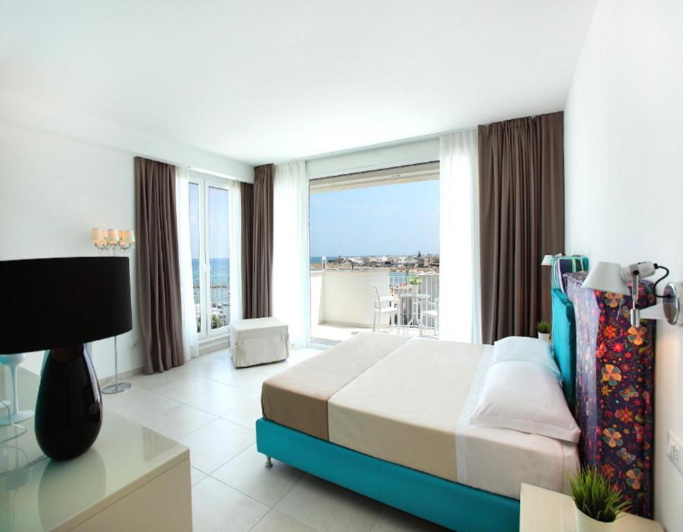 a bedroom with a bed and a large window at Hotel Cicò in Torre Santa Sabina