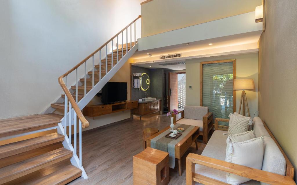 ein Wohnzimmer mit Treppe und Couch in der Unterkunft Moon Villa in Yangshuo
