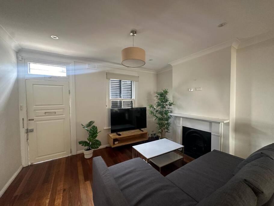 a living room with a couch and a flat screen tv at 3 Bedroom House Family Friendly Surry Hills 2 E-Bikes Included in Sydney