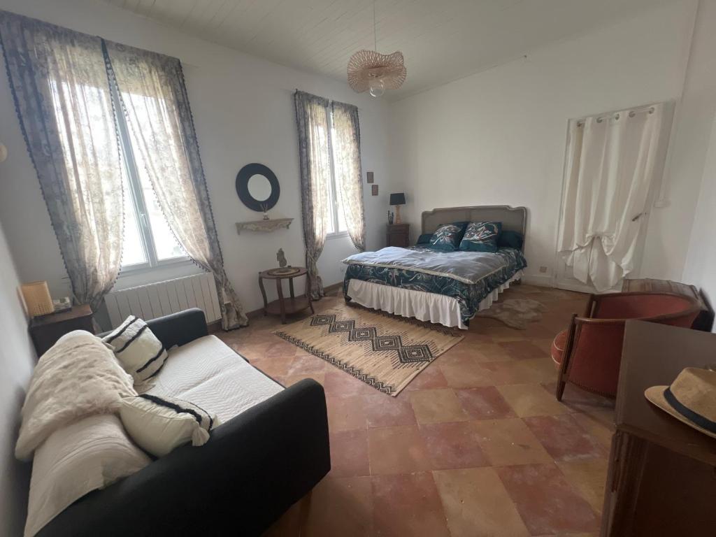 een woonkamer met een bank en een bed bij « La Souillarde » in Saint-Médard-en-Jalles