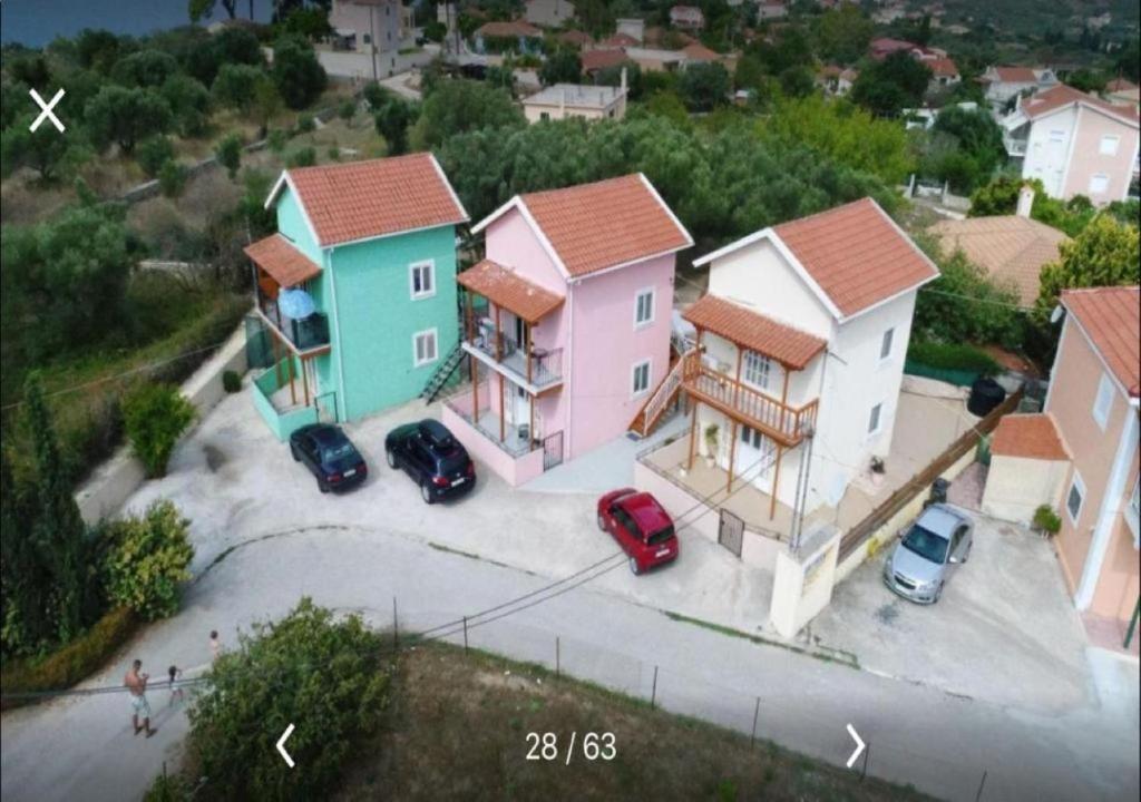 um grupo de casas com carros estacionados num parque de estacionamento em Kostas--Sarantis--2 em Lakíthra