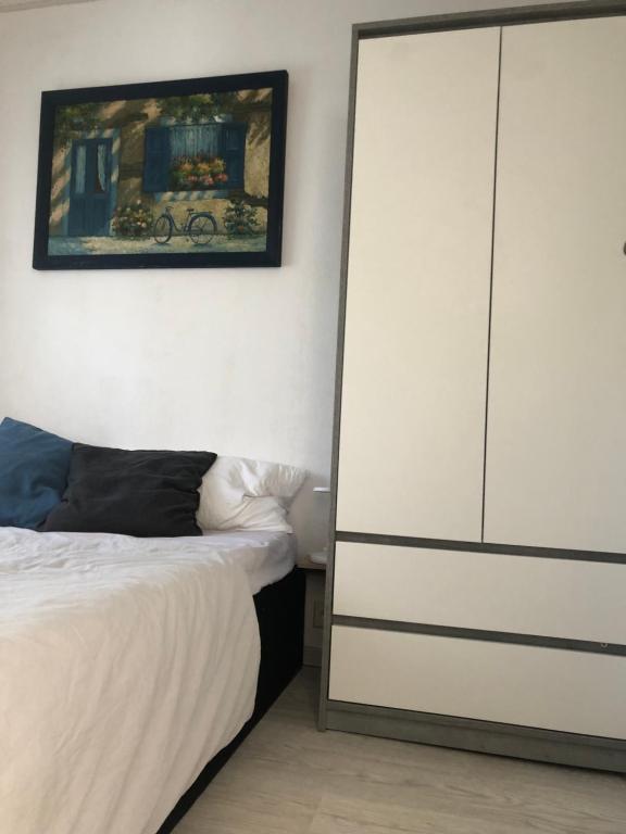 1 dormitorio con 1 cama y armario blanco grande en Ferienhaus am Netzener See, en Lehnin