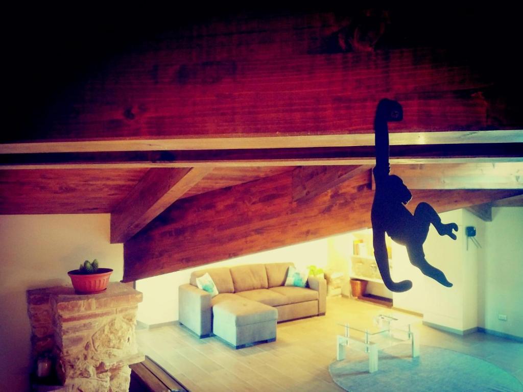 una sala de estar con sofá y un mono en el techo en Mansarda con splendida vista, en Moncalvo