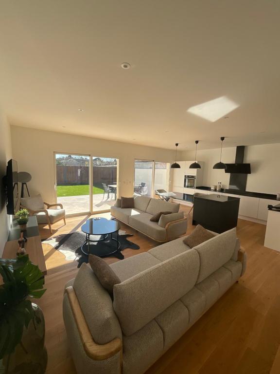 sala de estar con 2 sofás y cocina en Maison moderne à Carbon Blanc, en Carbon-Blanc