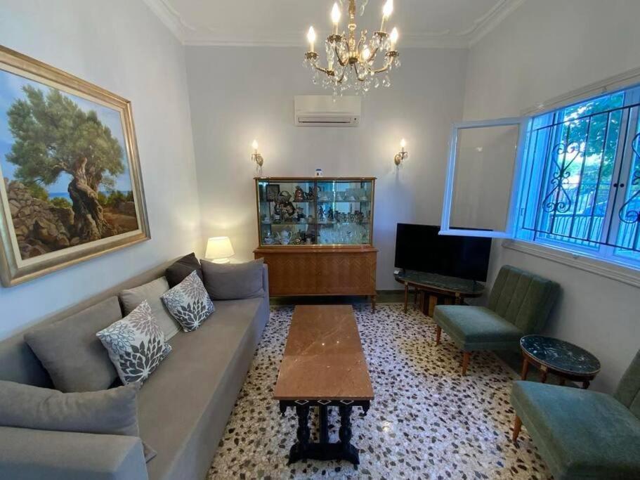 sala de estar con sofá y pecera en Lovely House with Private Carport & Shady Veranda, en Atenas
