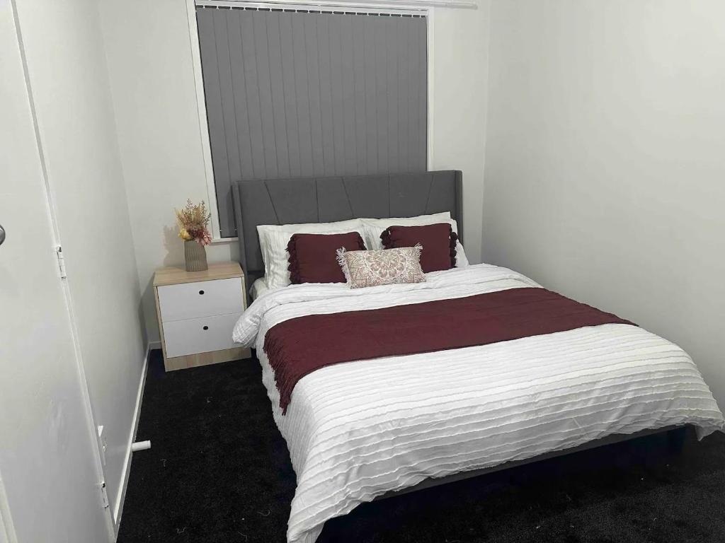 a bedroom with a large bed and a night stand at Cozy 3BR West Auckland in Auckland