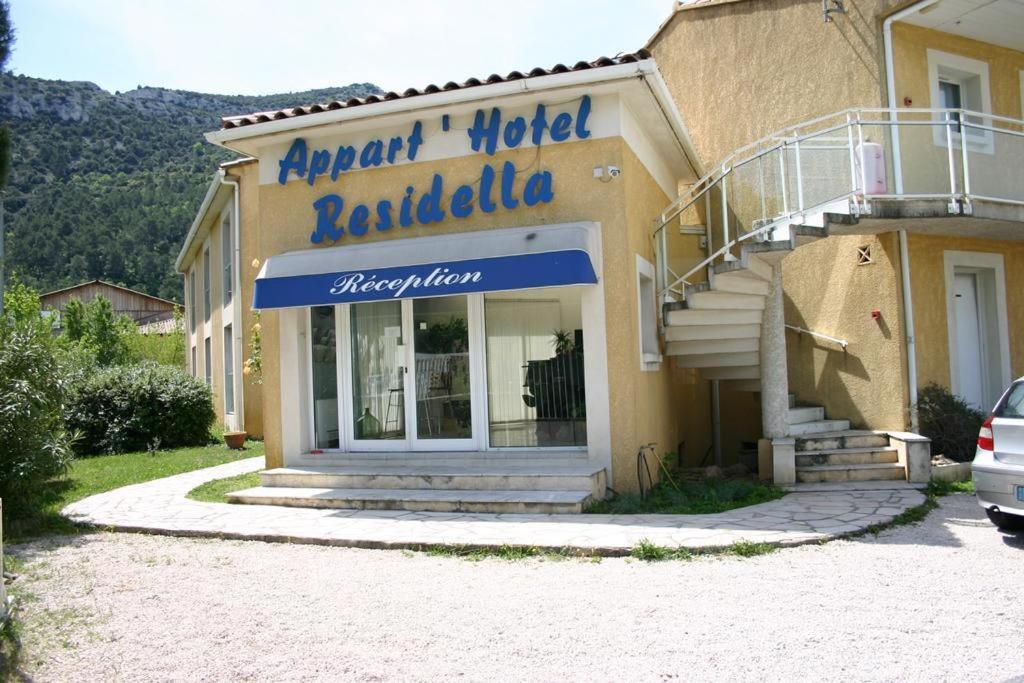 ein Hotel mit einem Schild an der Seite eines Gebäudes in der Unterkunft Résidence Hôtel Residella in Gémenos