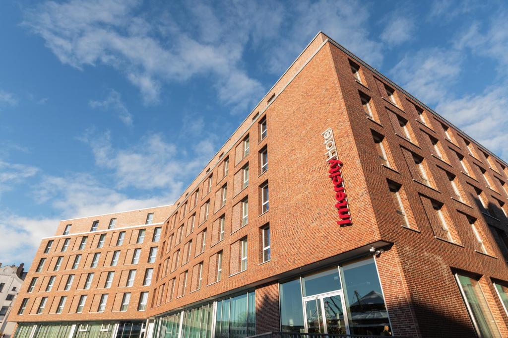 ein Backsteingebäude mit einem roten Schild darauf in der Unterkunft IntercityHotel Lübeck in Lübeck