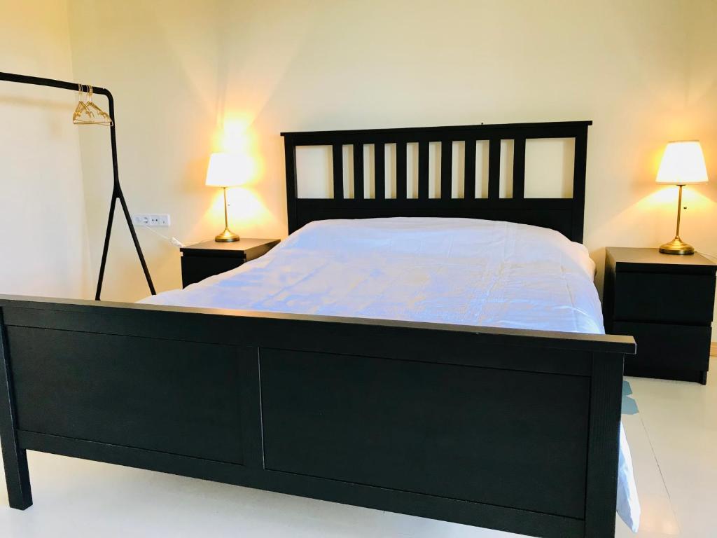 ein Schlafzimmer mit einem schwarzen Bett und zwei Nachttischen in der Unterkunft Architect Villa with Infinity Pool near Beach&Golf in Santa Cristina d'Aro