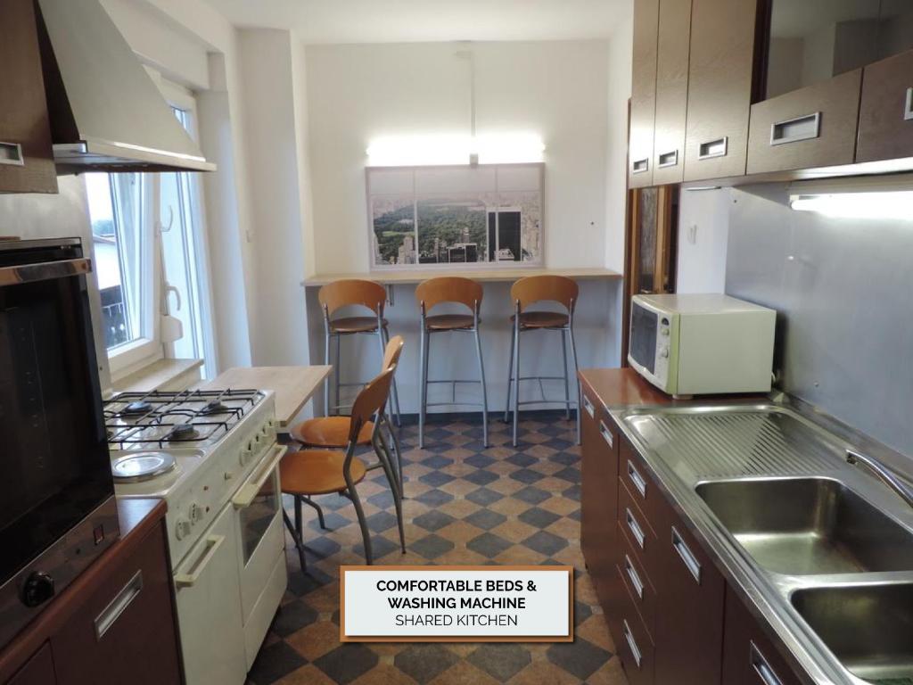 a kitchen with a counter with stools in it at Rooms Kozarje in Ljubljana