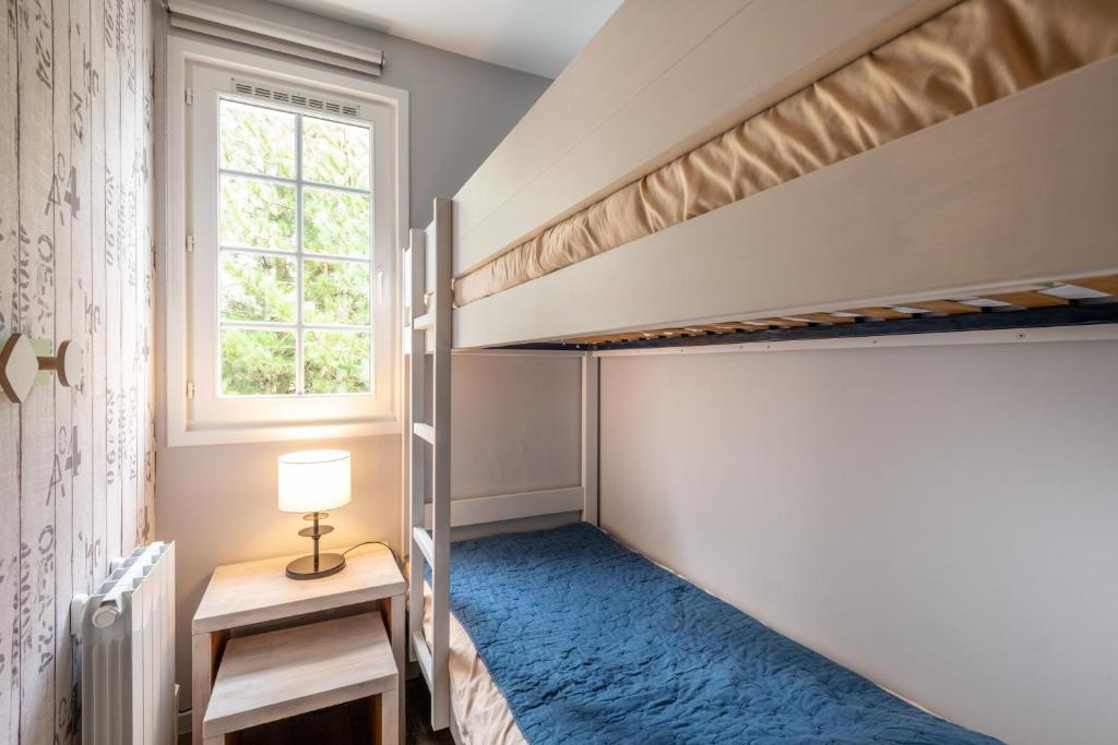 a bedroom with two bunk beds and a window at Belle Dune in Fort-Mahon-Plage