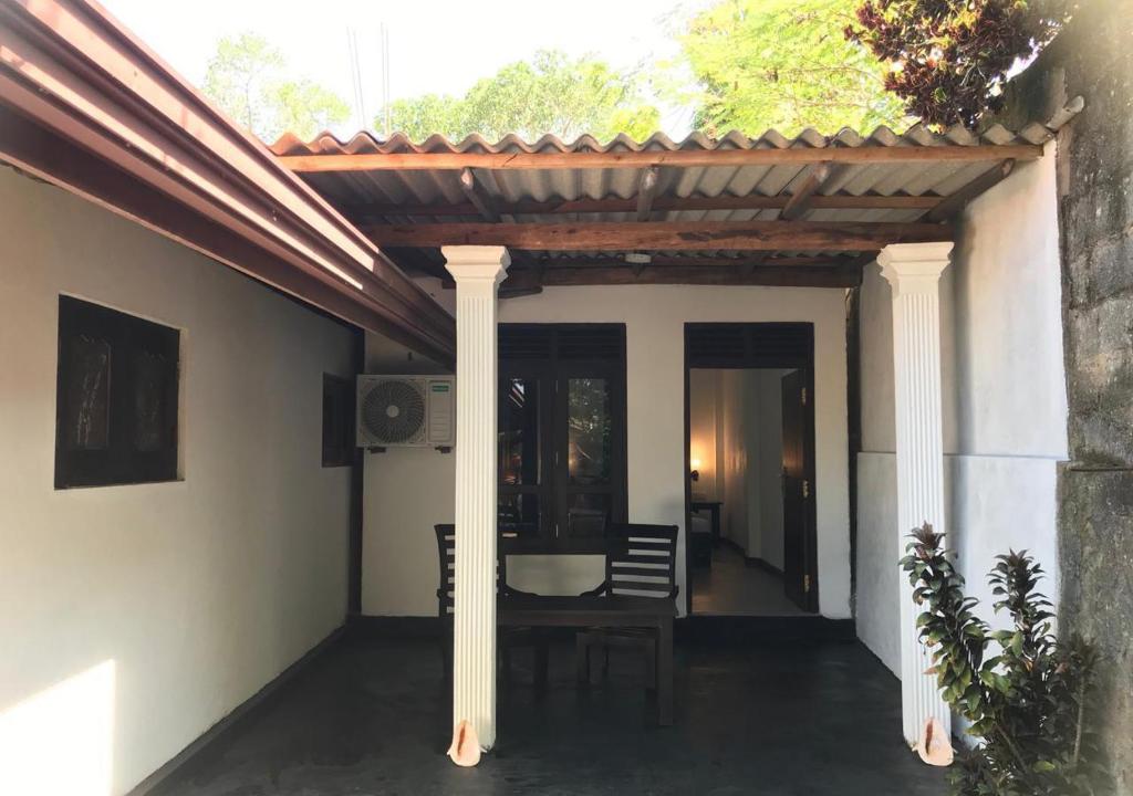 タンガラにあるThe silent sand homestayのパティオ(パーゴラ、テーブル、椅子付)