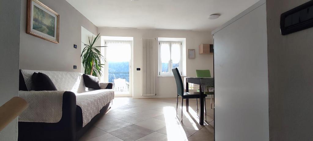 un soggiorno con divano, tavolo e finestra di Appartamento Alba a Folgaria