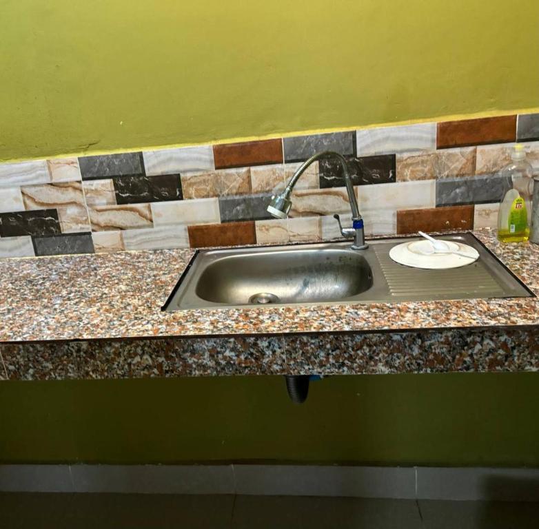 a stainless steel sink in a kitchen with a counter top at 2 Sisters Garden Bungalows in Kampot