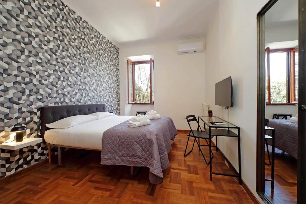 a bedroom with a bed and a table and a television at 4BNB - Donatello Apartment in Rome