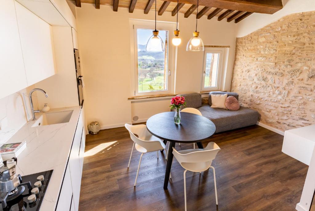a kitchen and living room with a table and a couch at Incanto a Spello: Raffinato Appartamento per Due in Spello