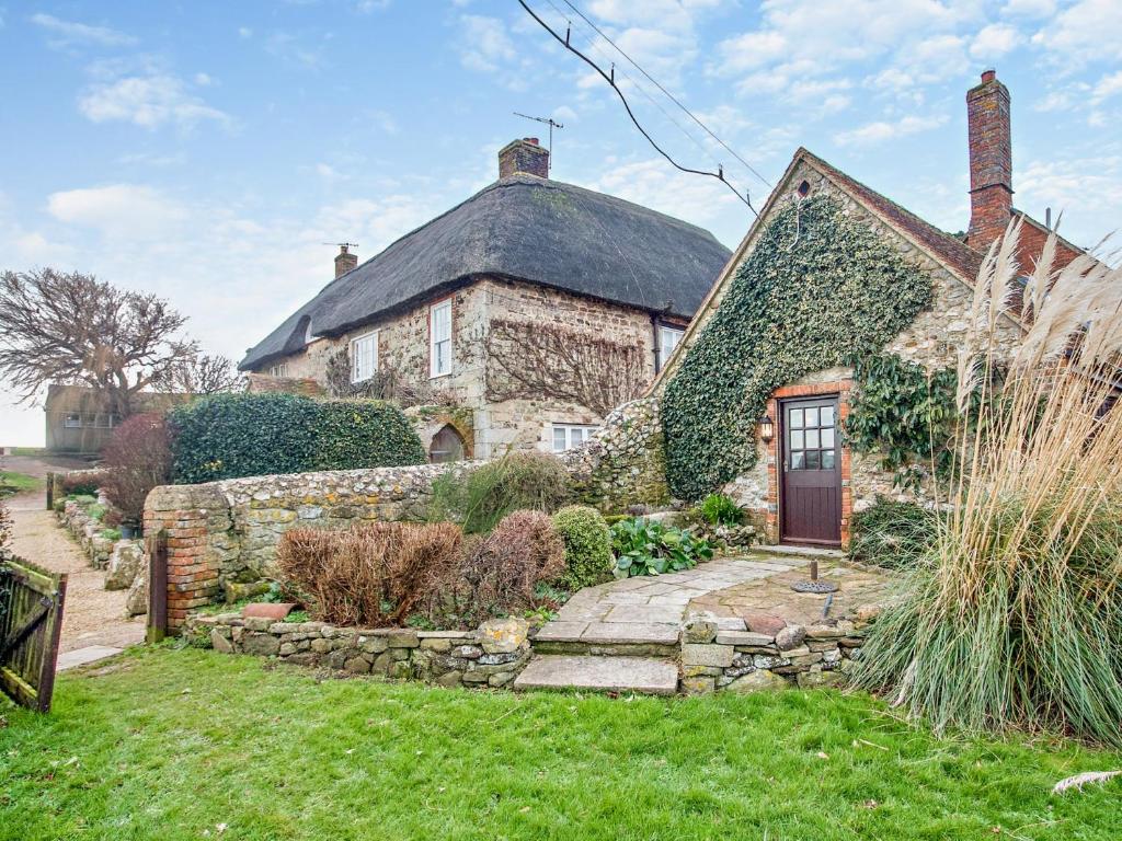 an old stone house with a stone wall at 2 Bed in Brighstone 94031 in Brighstone