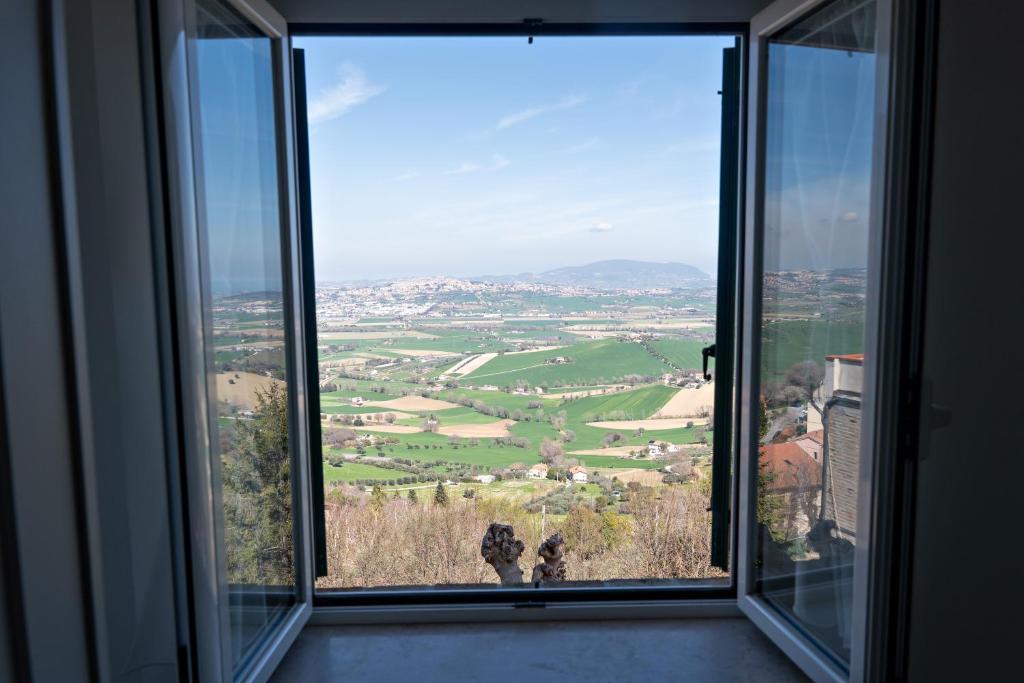 een raam met uitzicht op een groen veld bij Silenziosa Luna in Recanati