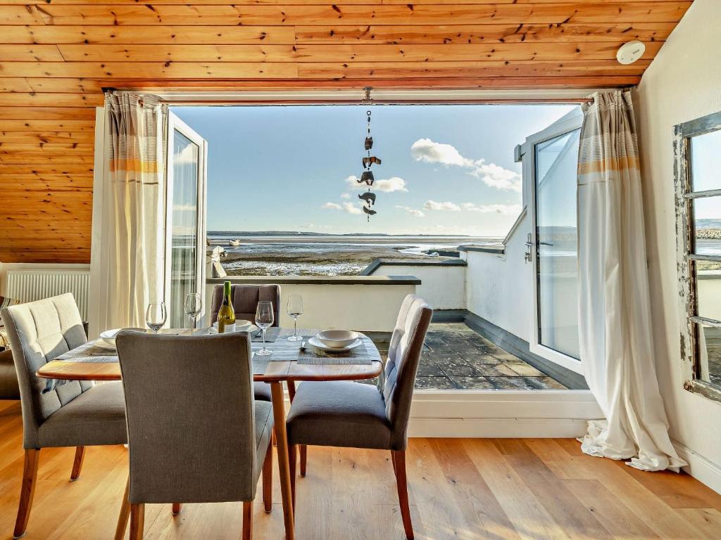 a dining room with a table and chairs and a large window at 2 Bed in Haverigg 94052 in Haverigg