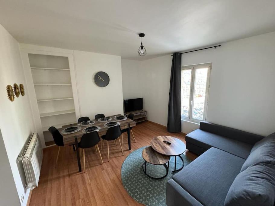 un salon avec un canapé, une table et des chaises dans l'établissement Le spacieux, au Havre