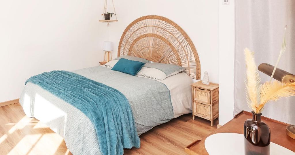 sypialnia z łóżkiem z drewnianym zagłówkiem w obiekcie Chambre Chalet de Thau w mieście Balaruc-le-Vieux
